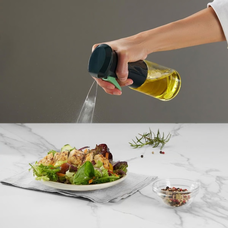 Aceitera Spray Lékué pulverizando aceite sobre una ensalada